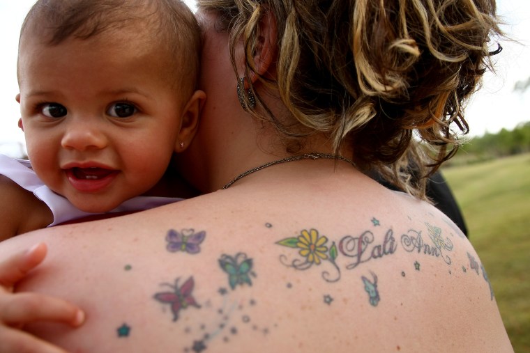 Lali Ann, 14 months, looking over her mom's tattoo.