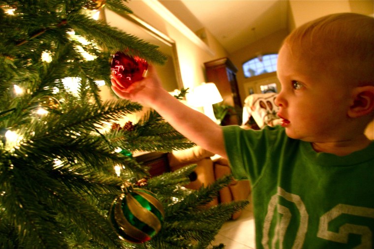 Gavin, 1, decorates his tree.