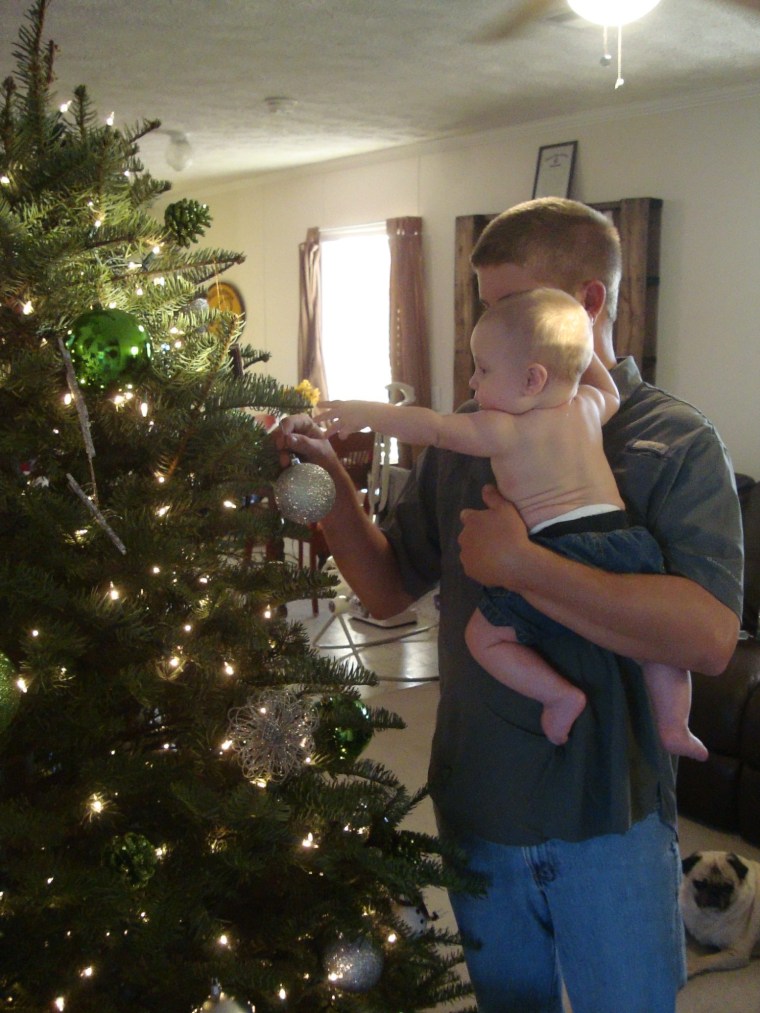 Noah, 5 months, decorating the tree with his Dad