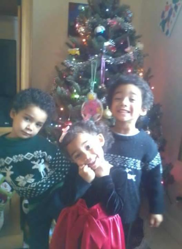4-year-old twins Kennedy and Kaelan and 2-year-old Geneva pose in front of their tree