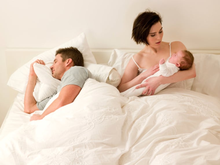 couple with baby in bed