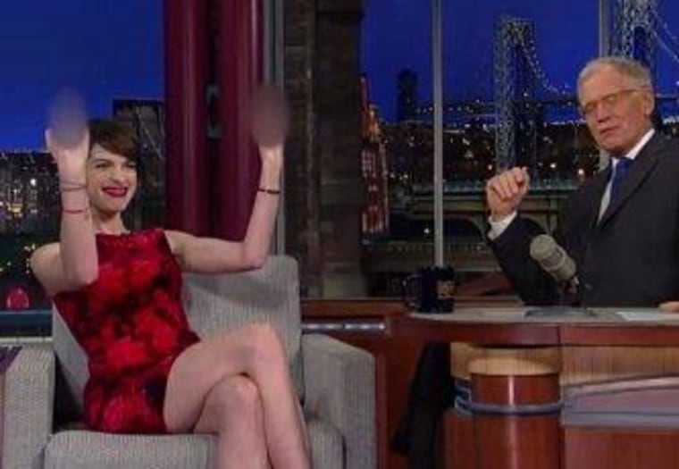 Anne Hathaway demonstrates her wedding day gesture for paparazzi.