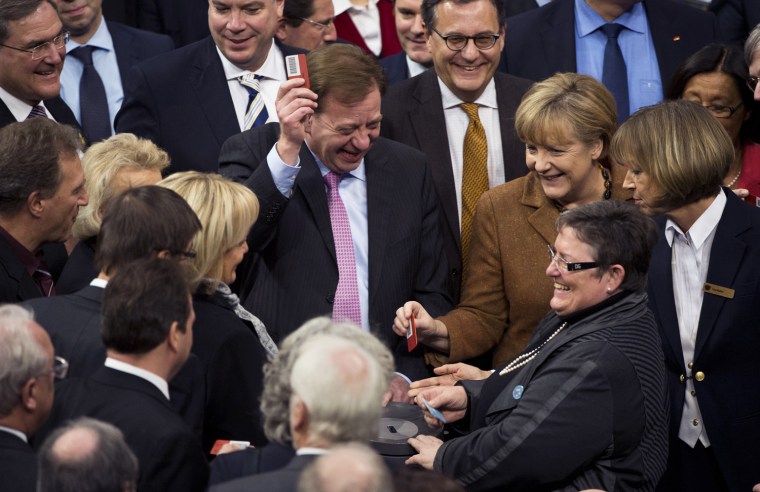 German Chancellor Angela Merkel, right, prepares Wednesday in Berlin to cast her ballot with other MPs after a debate in the German parliament's lower house over a law governing circumcision.