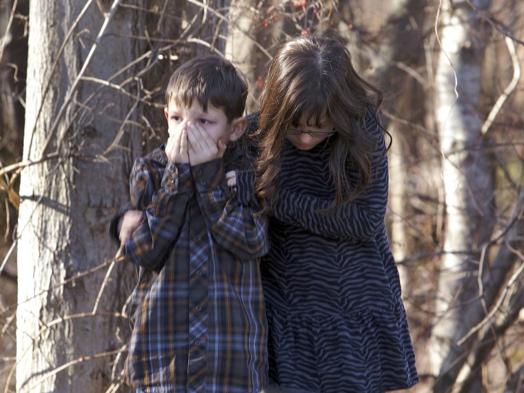 Young children wait outside Sandy Hook Elementary School after a shooting in Newtown, Connecticut, December 14, 2012. A shooter opened fire at the ele...