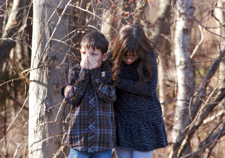 Young children wait outside Sandy Hook Elementary School after the shooting in Newtown, Conn., on Friday.