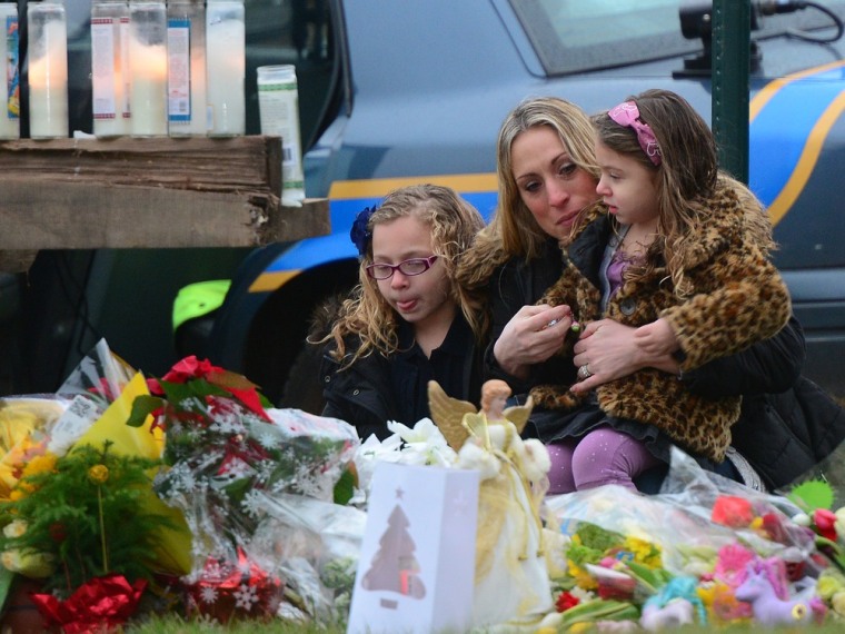 Parishioners pay their respects to the victims of an elementary school shooting while arriving for mass at St Rose of Lima Church in Newtown, Connecti...