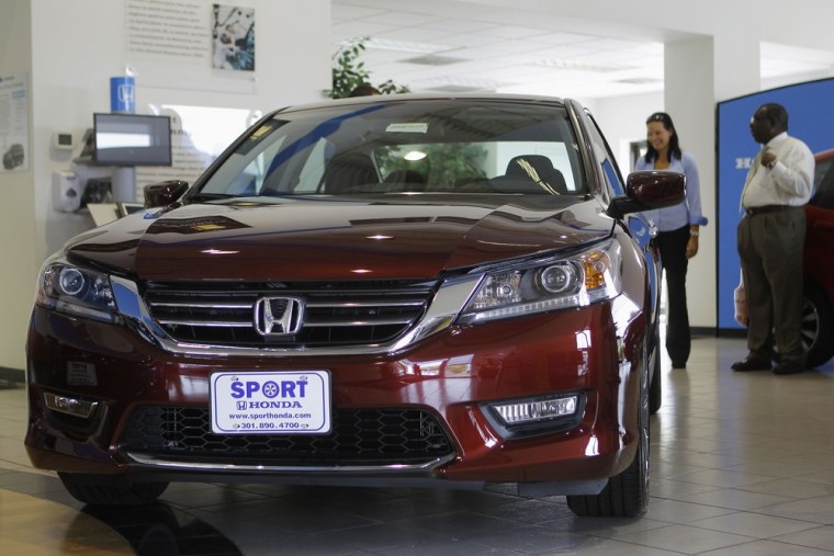 Sales personnel at Sport Honda look over the first 2013 Honda Accord to hit the showroom floor in Silver Spring, Maryland September 17, 2012. The Acco...