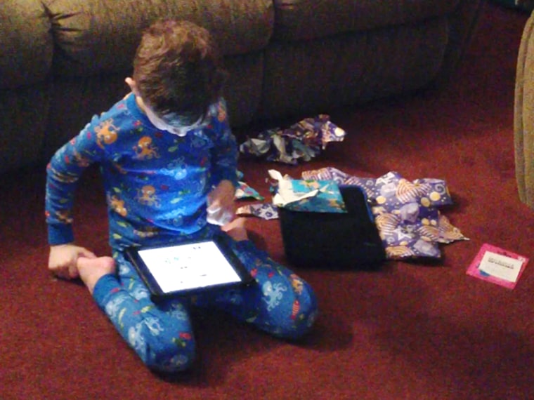 Ethan Funk looks at the iPad he got on the first night of Hanukkah.