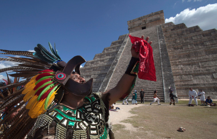 A man in Aztec warrior costume dances in front of the Pyramid of Kukulkan at Chichen Itza in the Mexican state of Yucatan on Thursday. The archaeological site was expecting a deluge of visitors on Friday, 12-21-12, to witness what some expect to be the end--or beginning--of an epoch.