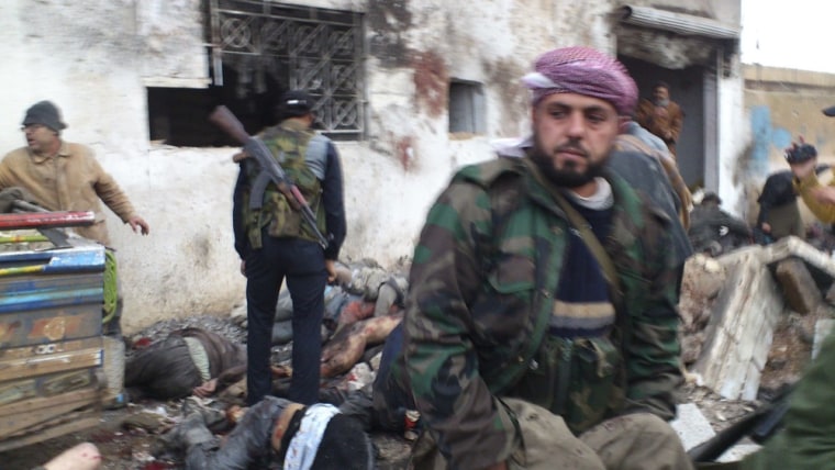 Free Syrian Army fighters and residents carry the bodies of people killed by what activists said were missiles fired by a Syrian Air Force fighter jet from forces loyal to Syria's President Bashar al-Assad at a bakery in Halfaya, near Hama, Sunday, Dec. 23.