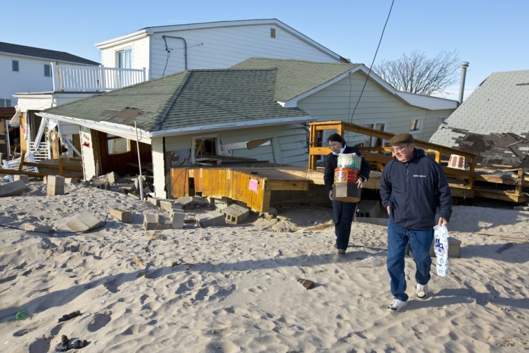 Pat and Cam Livingston stand outside their home at 220 Oceanside in Breezy Point, which was floated off of it's foundation by Superstorm Sandy.