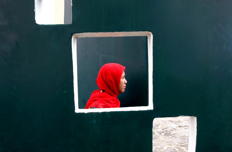 A woman is seen through an opening on a wall as she attends a prayer commemorating the 8th anniversary of the Indian Ocean tsunami in Banda Aceh, Aceh province, Indonesia, on Dec. 26.