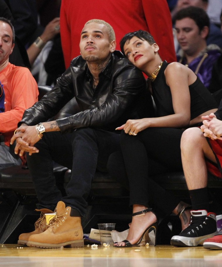 Rihanna, right, leans her head on Chris Brown as they sit together at the NBA basketball game between the New York Knicks and Los Angeles Lakers in Los Angeles on Tuesday, Dec. 25.
