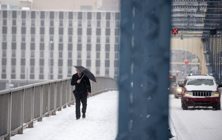 A pedestrian crosses the Smithfiled Street Bridge after a winter storm blanketed the Midwest with snow on Dec. 26, in Pittsburgh, Penn.
