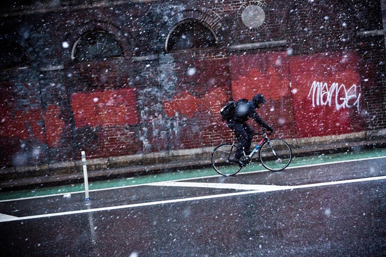 A cyclist rides his bike through a winter snowstorm on Dec. 26, in New York City. Snow, mixed with and changing to rain, is expected to hit the New York City area this afternoon into the evening.