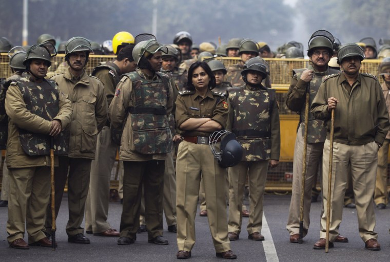Indian police stand guard in front of a barricade as protesters march towards them during a protest against a recent gang rape of a young woman in a moving bus in New Delhi on Dec. 27.