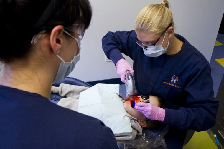Photo By Carl D. Walsh © 2012: Augusta Pediatric Dentistry assistant Molly Turner (L) and Dental Hygienist Diana DesRochers (R) apply a dental sealant...