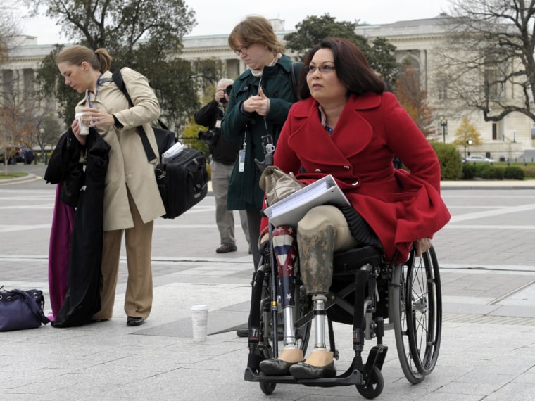 Rep.-elect Tammy Duckworth, D-Ill., an Iraq War veteran who lost both legs in combat before turning to politics, arrives for a group photo at the Capitol in Washington on Nov. 15.
