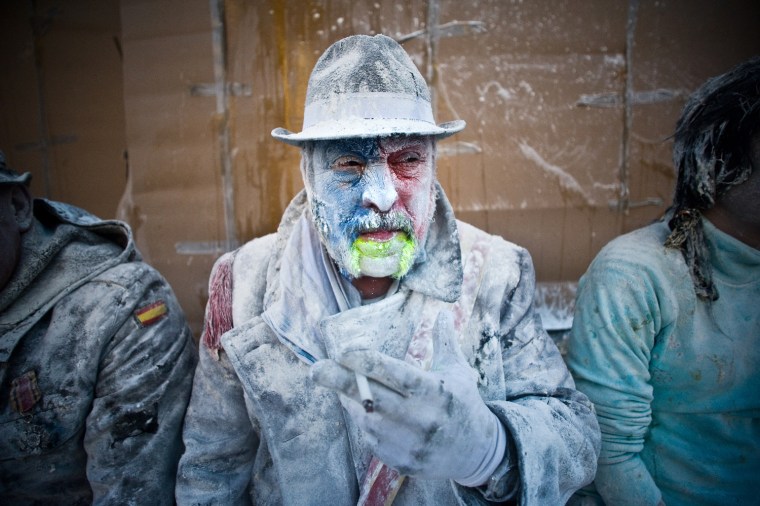 A reveler smokes during the battle of 'Enfarinats', a flour fight in celebration of the Els Enfarinats festival on Dec. 28, in Ibi, Spain.