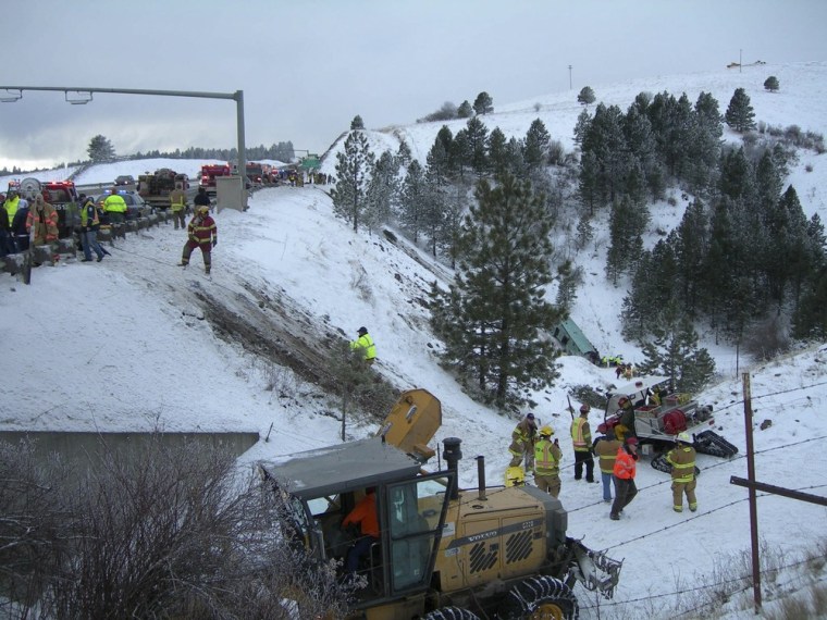 Rescue personnel respond to the scene of a charter bus crash on I-84, east of Pendleton, Oregon in this photo released on Dec. 30. Police said the bus may have gone out of control on the highway before crashing through a guardrail and down an embankment.