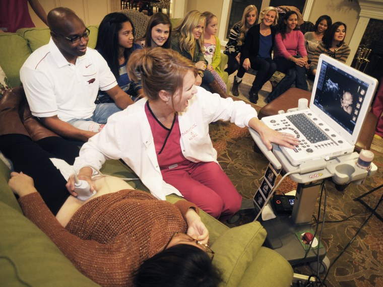 Christy Foster, co-owner of Babyface & More, does an ultrasound on expectant mother Karie Moss during a Babyface & More Ultrasound party at the home o...