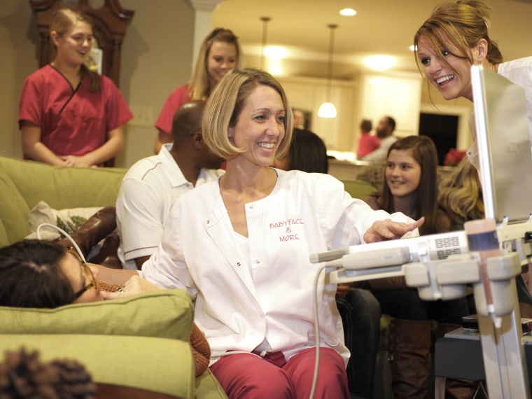 (L-R) Teena Gold, co-owner of Babyface & More, and her partner Christy Foster react to an ultrasound on expectant mother Karie Moss during a Babyface ...