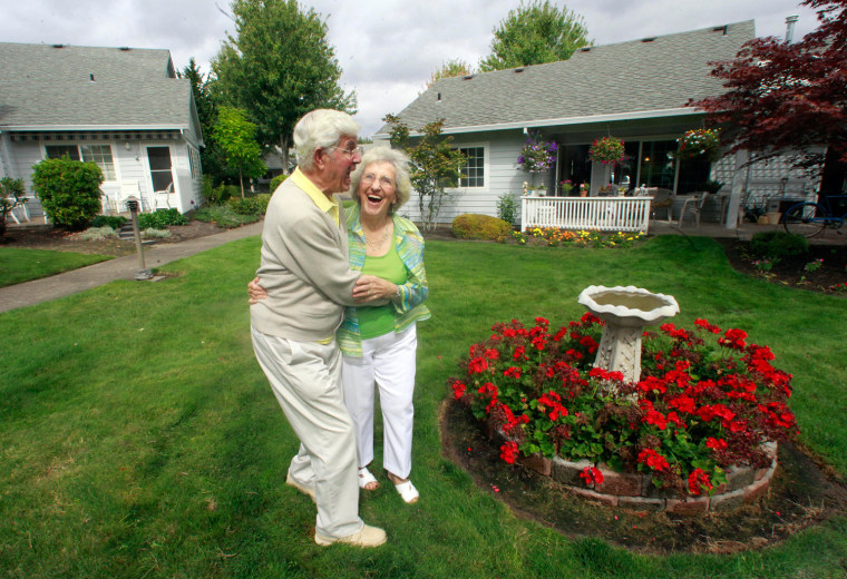 Bruce and Esther Huffman hug as they walk through their back yard Thursday, Sept. 15, 2011, in McMinnville, Ore. An elderly McMinnville couple has gained unexpected fame after their accidental webcam video reached viral status on YouTube. The three-minute clip of Bruce and Esther Huffman's attempt to snap a photograph on their new laptop computer had reached more than 285,000 viewers by Wednesday evening. (AP Photo/Rick Bowmer)