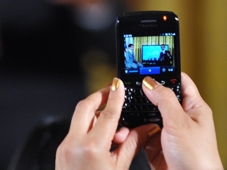 An attendee takes a photo with her cell phone as US President Barack Obama speaks during a \"Twitter Town Hall\" July 6, 2011 in the East Room of the White House in Washington, DC. AFP PHOTO/Mandel NGAN (Photo credit should read MANDEL NGAN/AFP/Getty Images)