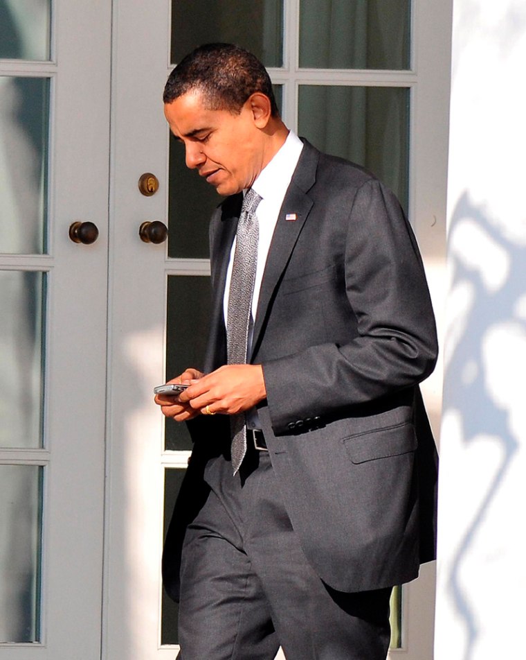 epa01618207 United States President Barack Obama works with his Blackberry as he returns to the Oval Office at the White House in Washington, D.C. 29 January 2009 after going to Sidwell Friends School in Bethesda, Maryland for a class presentation for his his daughter Sasha.  EPA/RON SACHS / POOL T