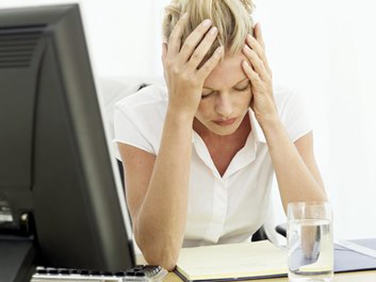 a woman sitting at a desk holding her head in pain work headache sick ill tired stressed job msnbc stock photo photography