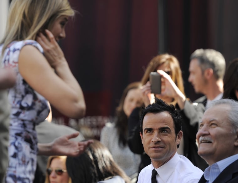 Actress Jennifer Aniston, left, greets her father, actor John Aniston, right, and her boyfriend, actor Justin Theroux, before she received a star on the Hollywood Walk of Fame in Los Angeles, Wednesday, Feb. 23, 2012. (AP Photo/Chris Pizzello)