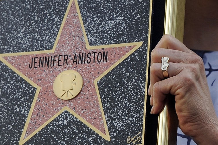 A ring, reading Jennifer, is seen on the hand of actress Jennifer Aniston as she holds up a replica of her new star on the Hollywood Walk of Fame in Los Angeles, Wednesday, Feb. 23, 2012. (AP Photo/Chris Pizzello)