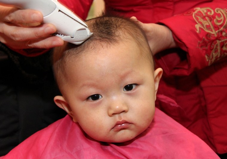 ZAOZHUANG, CHINA - FEBRUARY 23: (CHINA OUT) A child gets a haircut at a barbershop during the traditional festival known as Dragon Head Raising Day on February 23, 2012 in Hefei, China. Dragon Raises Head Day is celebrated on the second day of the second lunar month in China during which the traditional custom of getting a haircut is believed to bring good luck. (Photo by ChinaFotoPress/ChinaFotoPress via Getty Images)