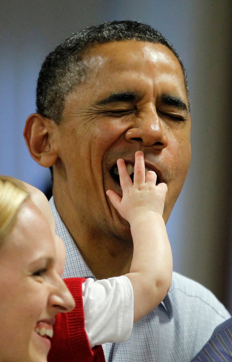 U.S. President Barack Obama tries to evade the fingers of eight-month-old Cooper Wall Wagner as he poses for a picture with his parents, Captain Greg Wagner and Meredith Wagner (L), as Obama met U.S. Marines and their families having lunch at Kaneohe Bay Marine Corps base in Hawaii December 25, 2011. REUTERS/Jason Reed (UNITED STATES - Tags: POLITICS TPX IMAGES OF THE DAY)