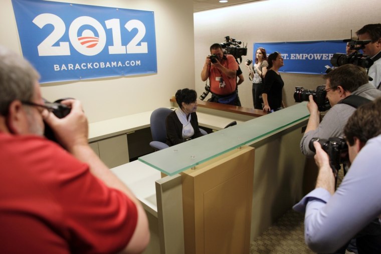 Volunteer receptionist Hattie Hester answers the phone while surrounded by photographers as they toured President Barack Obama's new campaign headquarters in Chicago May 12, 2011.