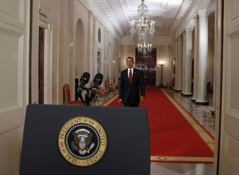 President Barack Obama re-enacts his walk to the lecturn after announcing live on television the death of Osama bin Laden, from the East Room of the White House in Washington, May 1, 2011.