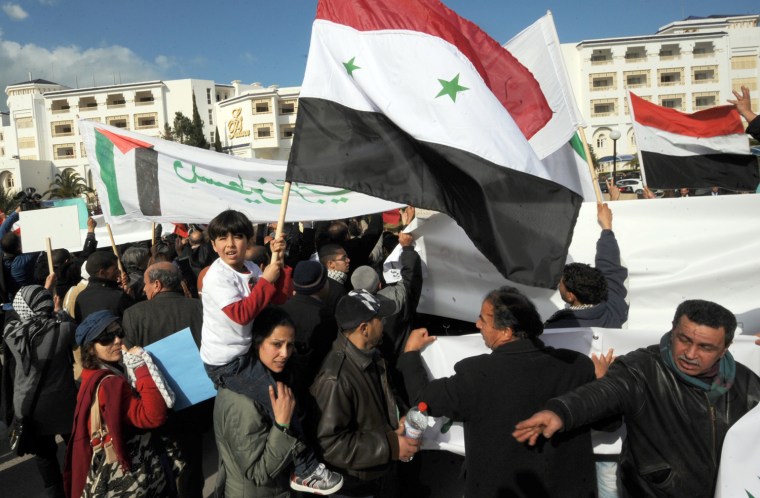 Tunisian and Syrian's Bashar al Assad Supporters shout slogans during a demostration in front of the conference hotel during the first
