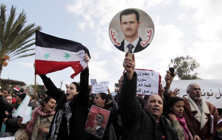 epa03120103 Supporters of Syrian President Bashar Al-Assad shout slogans outside the venue where Friends of Syria conference is convening, in Tunis, Tunisia, 24 February 2012. Hundreds of supporters of al-Assad protested outside the planned Friends of Syria conference on 24 February, calling the participants 'enemies of Syria.' The crowd consisted largely of leftist Tunisians. The protesters were prevented by security guards from coming close to the building where the conference was to be held. EPA/MOHAMED MESSARA
