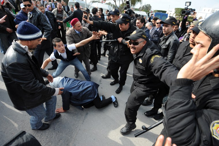 Tunisian police wielding batons beat back several dozen protesters trying to enter the venue of an international meeting on the Syria crisis in Tunis on February 24, 2012. Western and Arab nations are to challenge Syria to allow in desperately needed humanitarian aid at a meeting today aimed at tackling President Bashar al-Assad's increasingly bloody crackdown. AFP PHOTO / FETHI BELAID (Photo credit should read FETHI BELAID/AFP/Getty Images)
