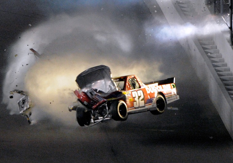 Miguel Paludo (32), of Brazil, goes airborne after a crash during the NASCAR Camping World Truck series 250 auto race in Daytona Beach, Fla., Friday, Feb. 24, 2012. (AP Photo/Phelan M. Ebenhack)