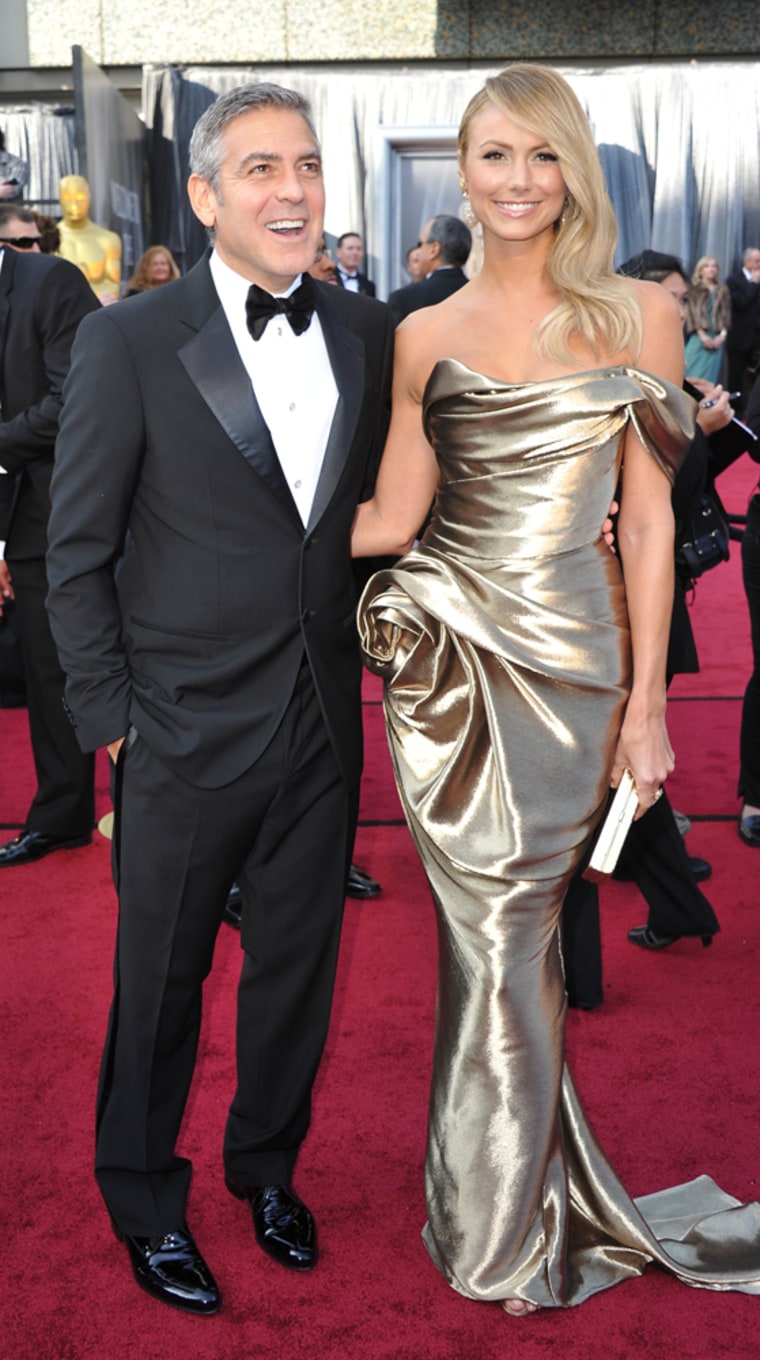 George Clooney and Stacy Keibler arrive on the red carpet for the 84th Annual Academy Awards on February 26, 2012 in Hollywood, California. AFP PHOTO Joe KLAMAR (Photo credit should read JOE KLAMAR/AFP/Getty Images)