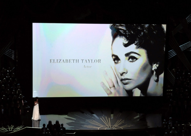 HOLLYWOOD, CA - FEBRUARY 26:  Images from the 'In Memoriam' monstage appear while Esperanza Spalding performs onstage during the 84th Annual Academy Awards held at the Hollywood & Highland Center on February 26, 2012 in Hollywood, California.  (Photo by Kevin Winter/Getty Images)
