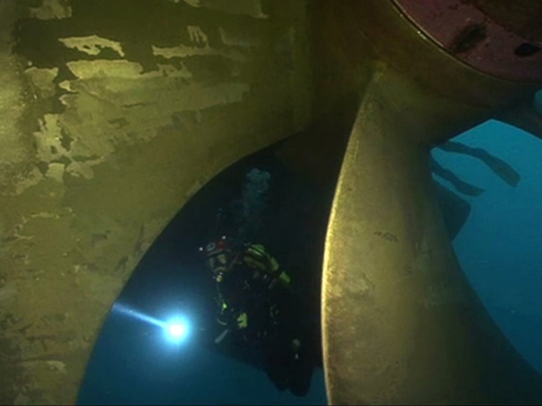 A scuba diver inspects the Costa Concordia cruise ship which ran aground off the west coast of Italy at Giglio island in this still image taken from video shot by Italian firefighters, February 1, 2012. Rough seas and strong winds on Wednesday morning prevented rescue, salvage and anti-pollution operations from taking place in the waters off the Italian island of Giglio, where the cruise ship Costa Concordia lies capsized. REUTERS/Vigili del Fuoco/Handout (ITALY - Tags: DISASTER TRANSPORT) FOR EDITORIAL USE ONLY. NOT FOR SALE FOR MARKETING OR ADVERTISING CAMPAIGNS