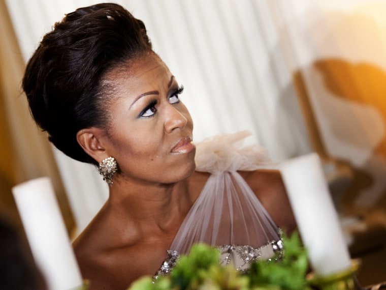 WASHINGTON - FEBRUARY 26: (AFP-OUT) First lady Michelle Obama listens to President Barack Obama speak in the State Dining Room of the White House February 26, 2012 in Washington, DC. President Obama and first lady Michelle Obama hosted 2012 Governors Dinner which coincides with the yearly meeting of the National Governors Association meeting in DC. (Photo by Brendan Smialowski/Getty Images)