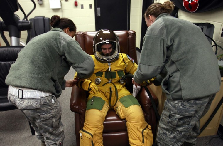 In this photo taken on Feb. 16, 2012, U.S. Air Force U-2 spy plane pilot Major Colby is assisted to put on a spacesuit and an astronaut-style fishbowl helmet for demonstration at the U.S. airbase in Osan, south of Seoul, South Korea. The long-winged, glider-like