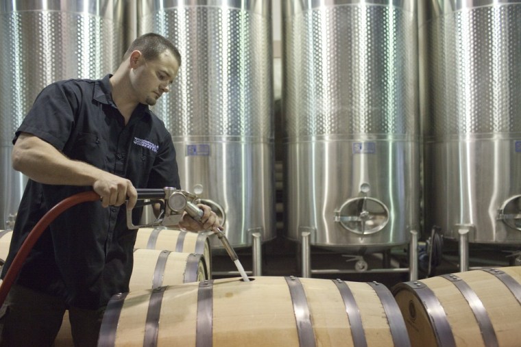 Brett Carlile, co-owner of Woodinville Whiskey Co., fills a barrel with unaged whiskey.