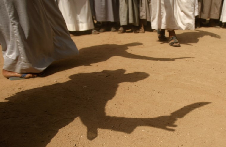 Shadows of tribesmen are cast on the ground as they perform the traditional Baraa in the province of Saada, Yemen on July 12, 2012.