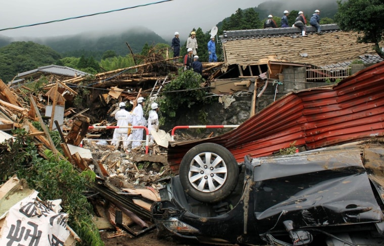 Police officers search for missing villagers following a mudslide in Minamiaso, Kumamoto Prefecture on July 12, 2012.