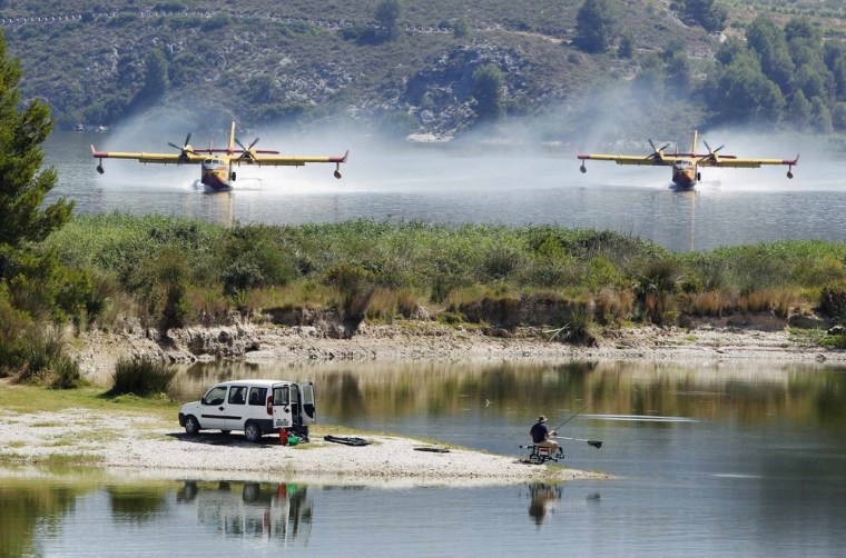 Firefighting planes fetch water from the Beniares reservoir to fight a wildfire next to the Sierra Mariola Nature Park in Cocentaina near Alicante, July 13.