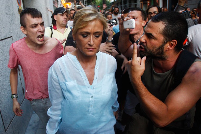 Demonstrators shout against the provincial representative of the Government, Maria Cifuentes, centre, during a protest against the recent austerity measures on Friday.